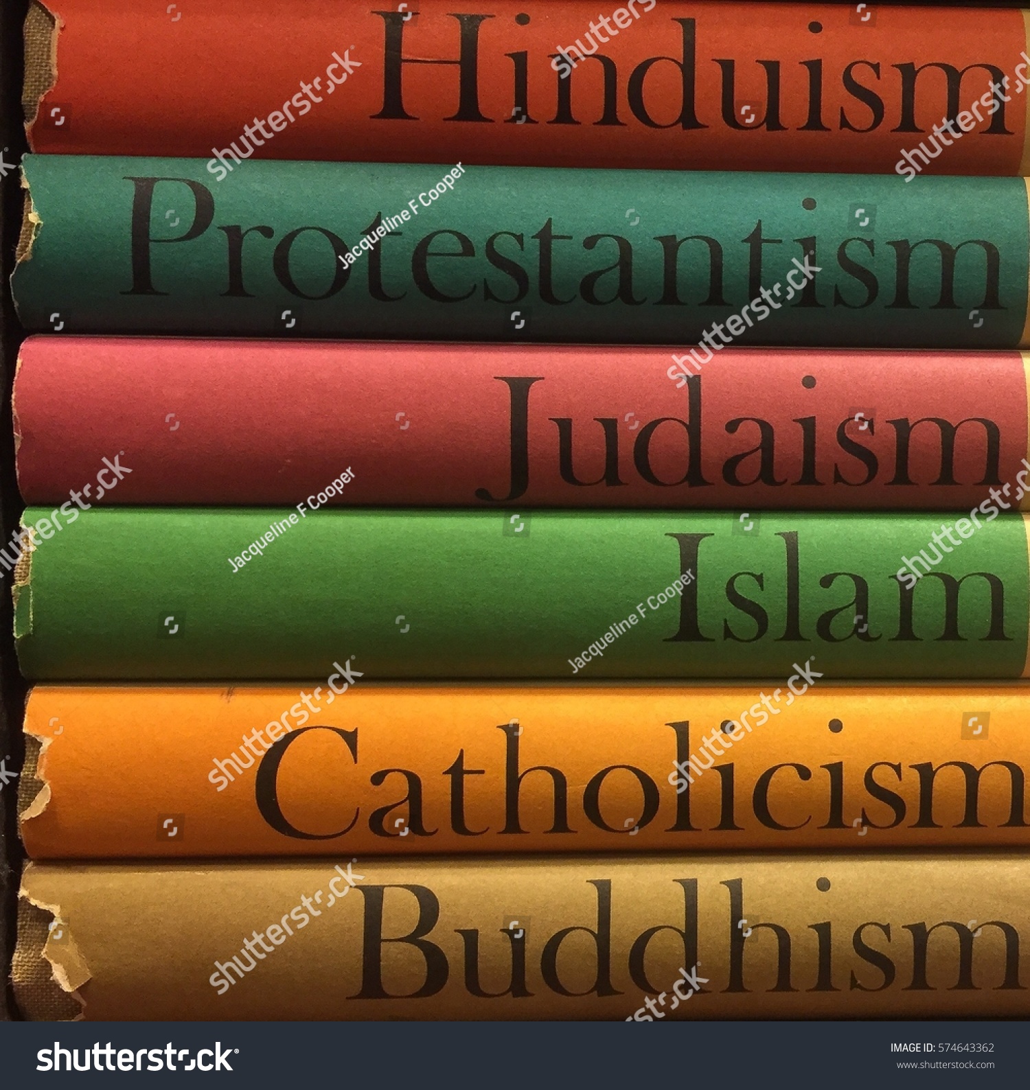 Stack of colorful books of different religions: Islam, Catholicism, Buddhism, Judaism, Protestantism, Hinduism #574643362