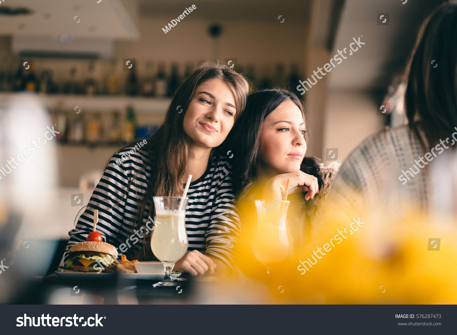 Old friends meeting up after long time for drinks and eating, talking about their memories. Girlfriends showing signs of affection, reliving beautiful moments from the past, being happy. #576287473