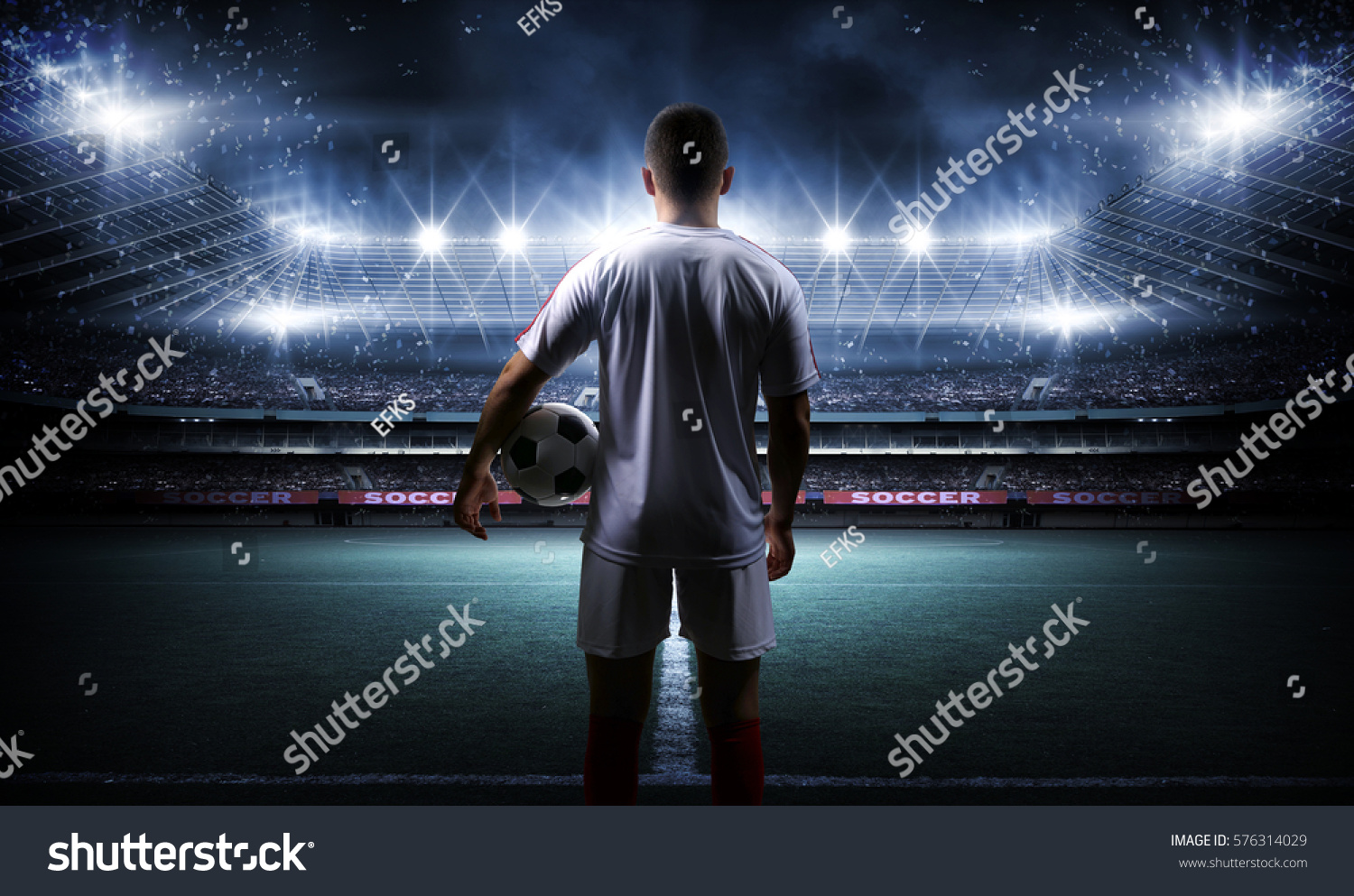 Football player with ball on field of stadium #576314029