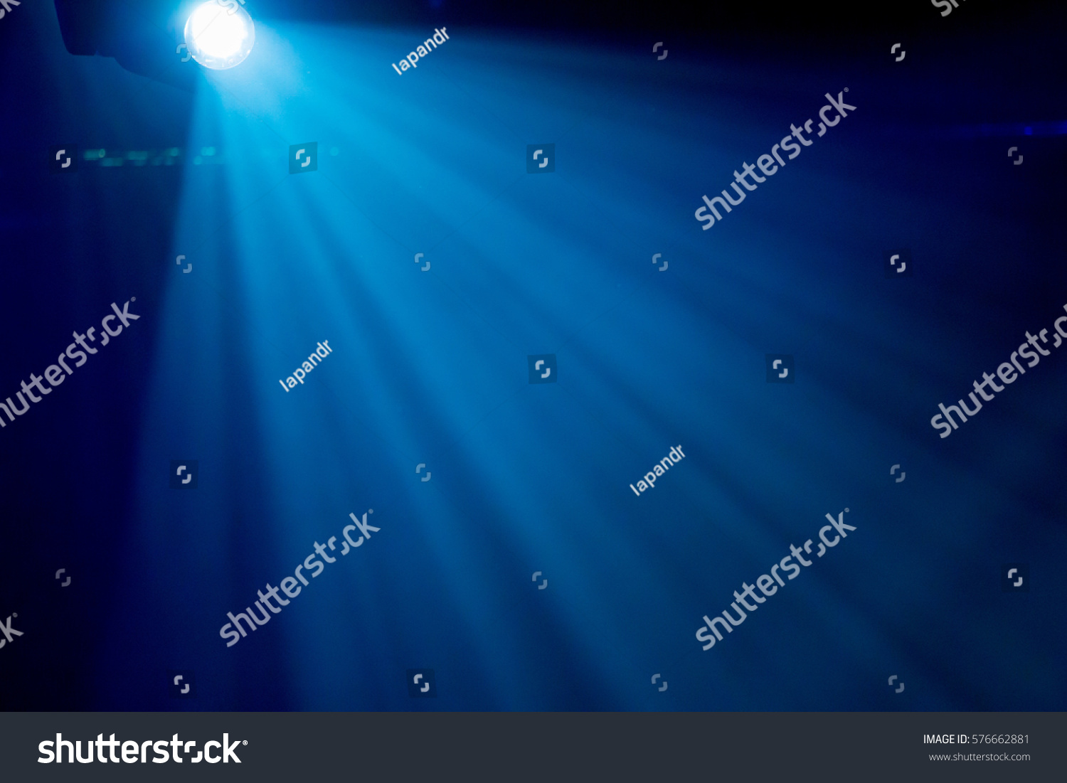 The rays of searchlights in smoke on stage during a performance #576662881