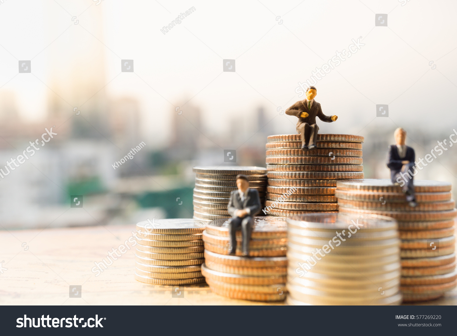 Miniature people: Small businessmen sitting on stack of coins, Money, Financial, Business Growth concept. #577269220