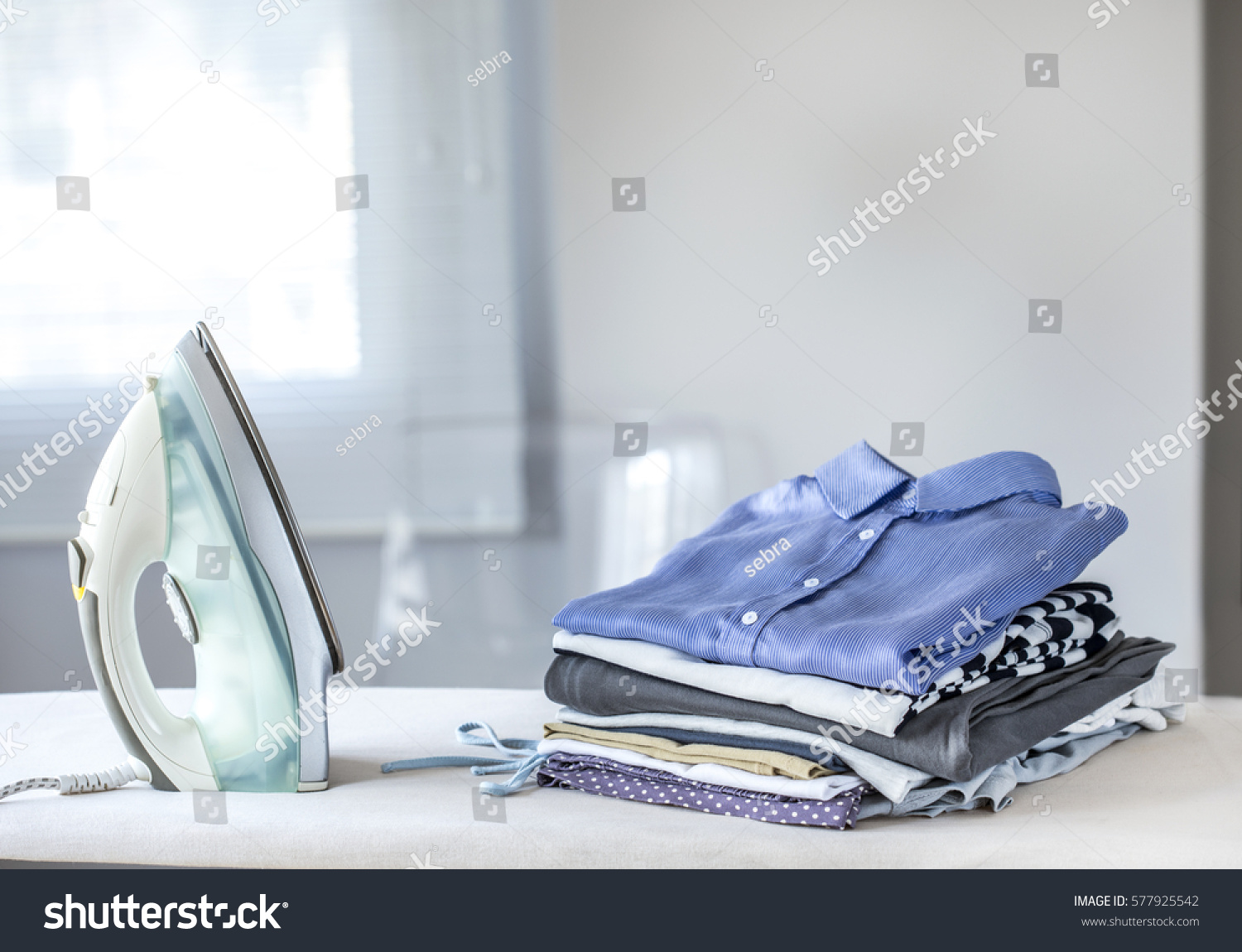 Ironing clothes on ironing board #577925542