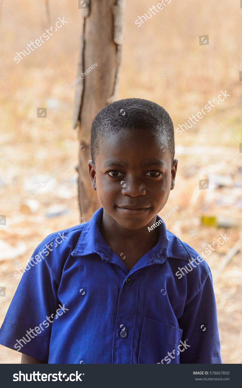 PIRA, BENIN - JAN 12, 2017: Unidentified Beninese little boy in a blue school uniform. Benin kids suffer of poverty due to the bad economy. #578667850