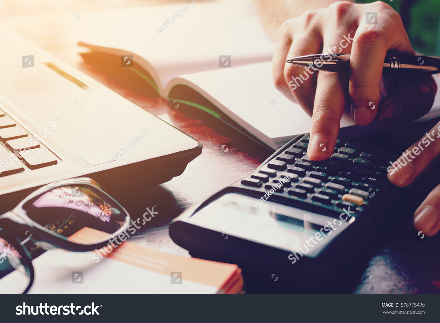 Close up woman doing finance at home office with calculate expenses #578775499