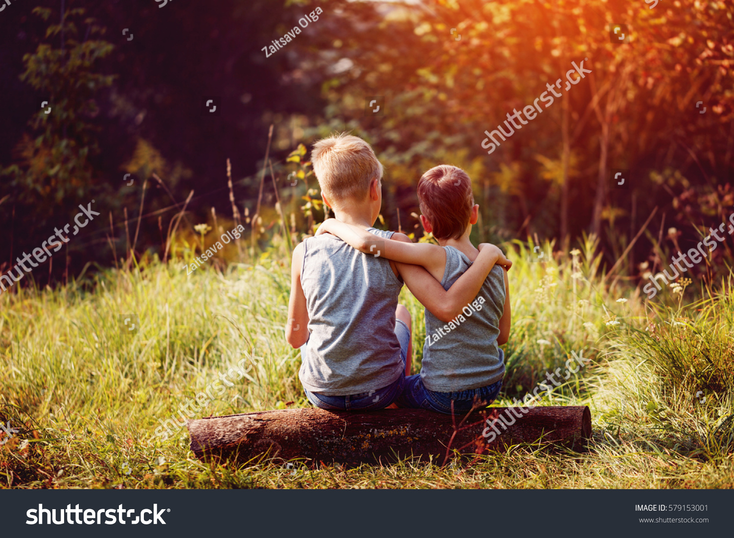 Two little boys friends hug each other in summer sunny day. Brother love. Concept friendship. Back view. #579153001