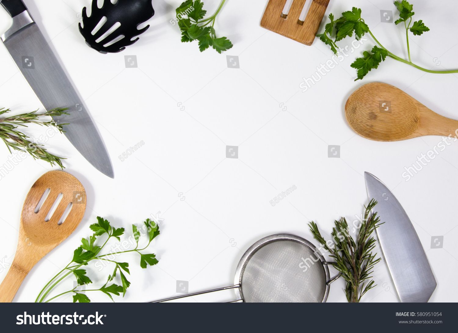 Concept idea for advertising or presentation in food industry, menus, brochures for restaurants. Copy space or room for text on white background, with kitchen utensils and parsley leaves scattered. #580951054
