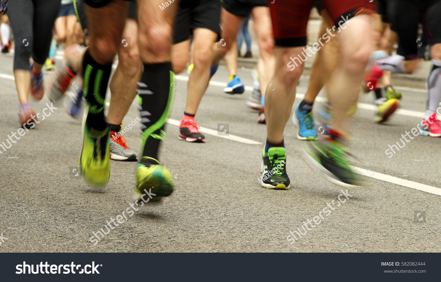 Runners feet on the road in blur motion during a long distance running event #582082444