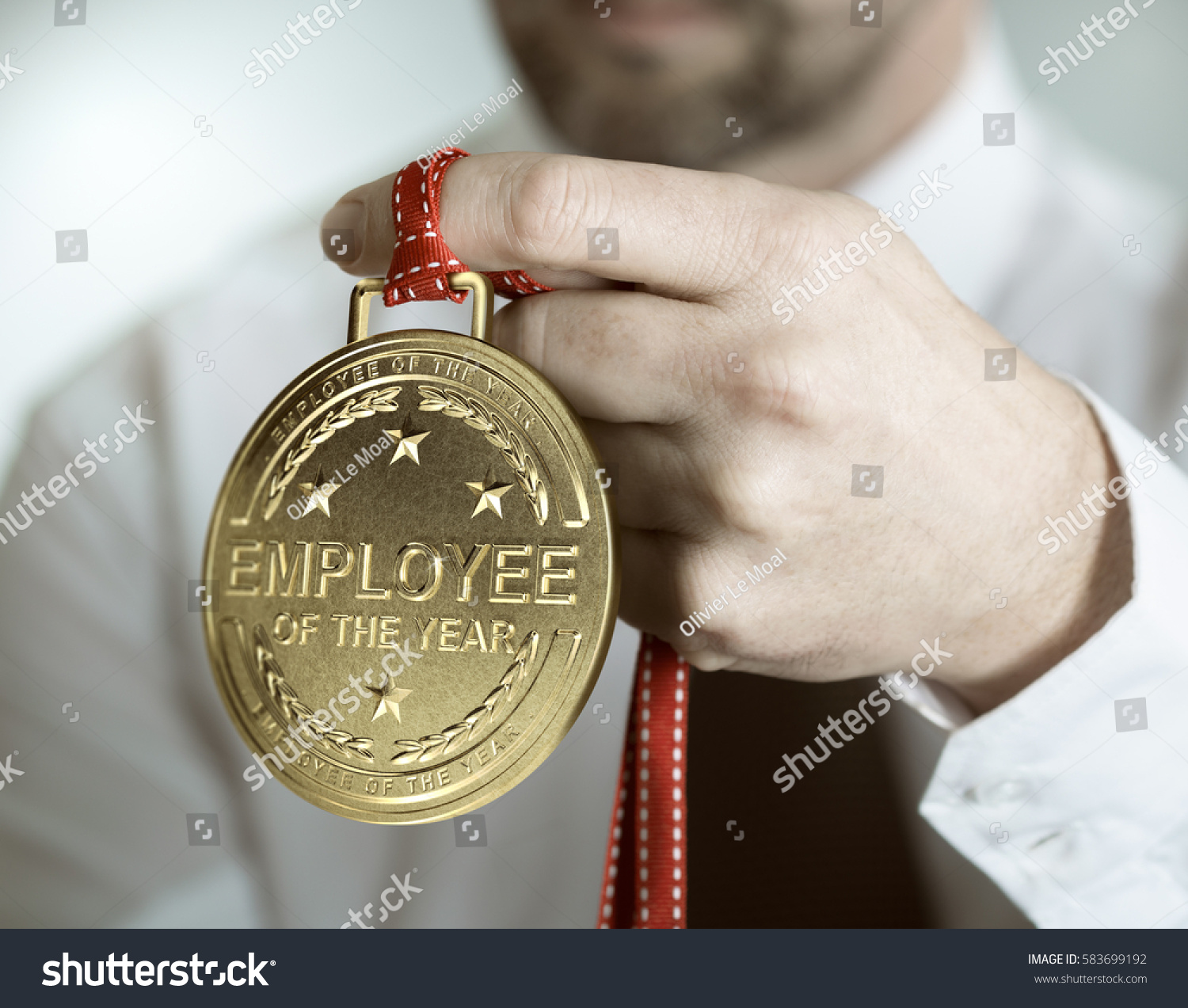 Employee holding golden medal with the text employee of the year. Incentive or motivation concept #583699192