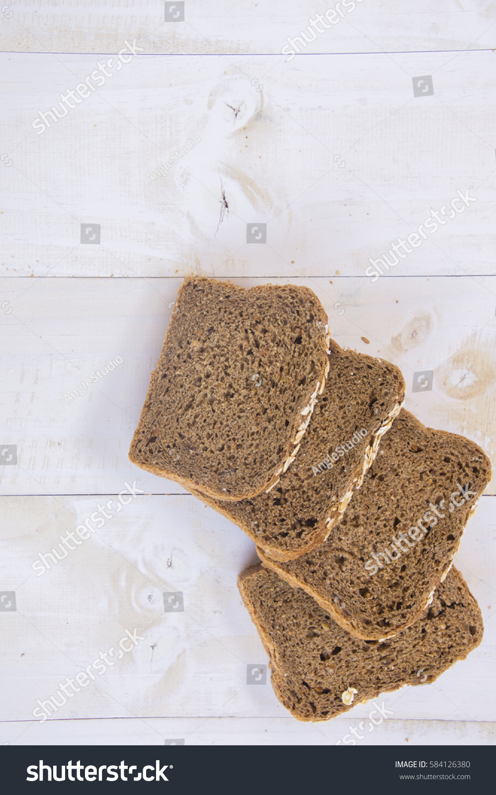 Fresh whole grain bread on white wood background #584126380