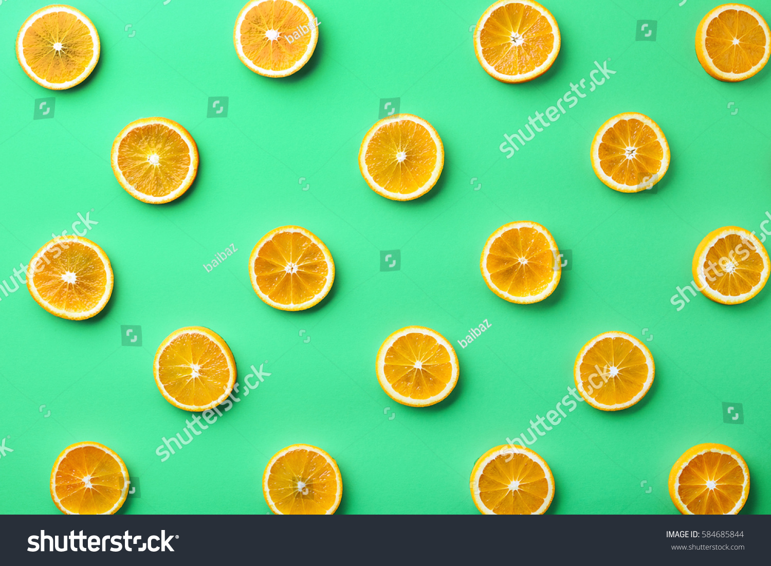 Colorful fruit pattern of fresh orange slices on green background. From top view #584685844