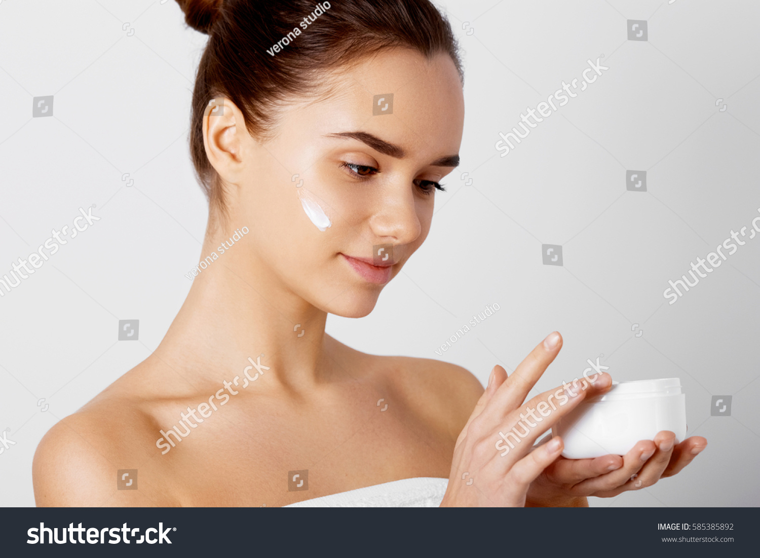 Skincare. Beauty Concept. Young pretty woman holding cosmetic cream #585385892