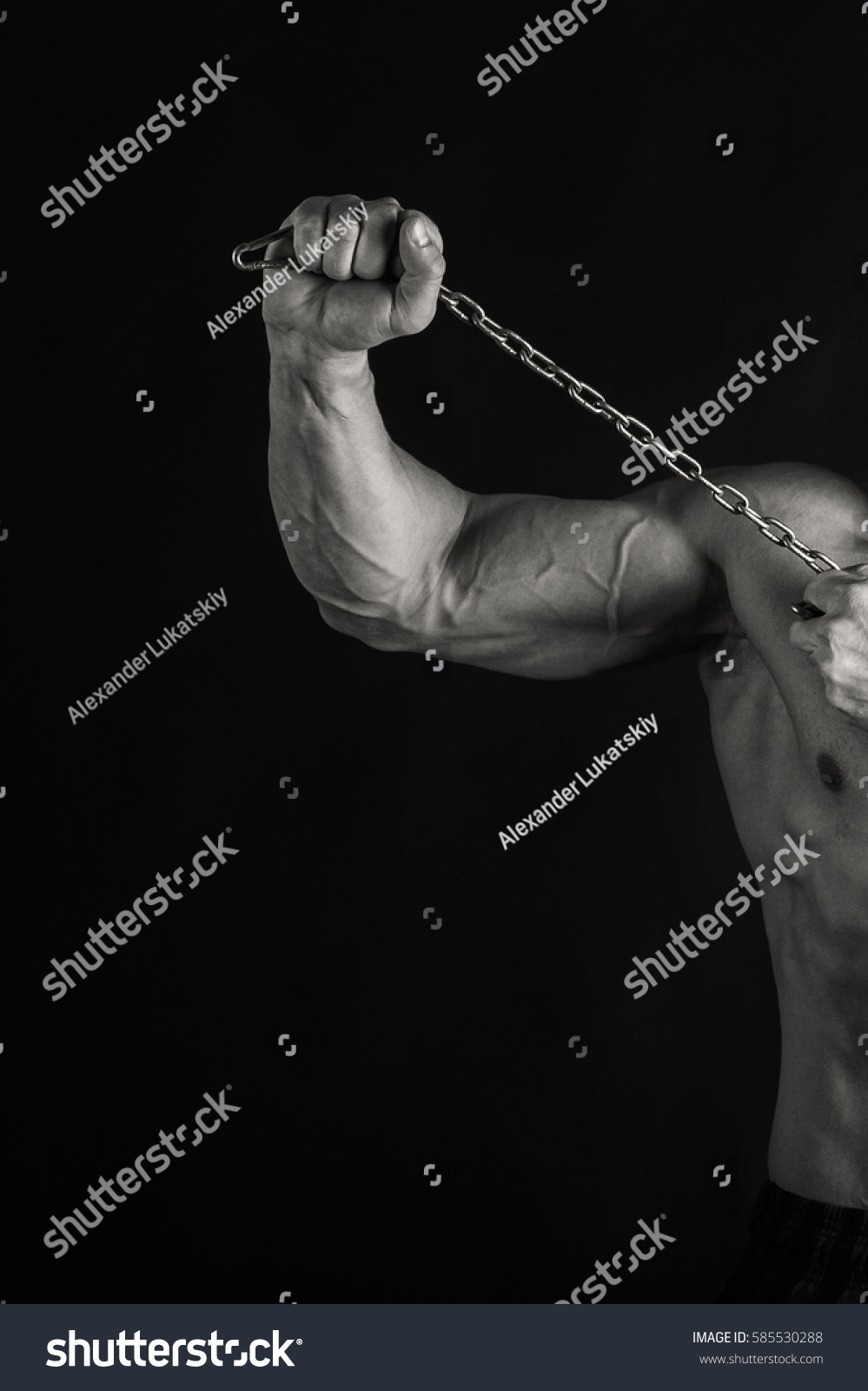 Bodybuilder posing in different poses demonstrating their muscles. Failure on a dark background. Male showing muscles straining. Beautiful muscular body athlete. #585530288