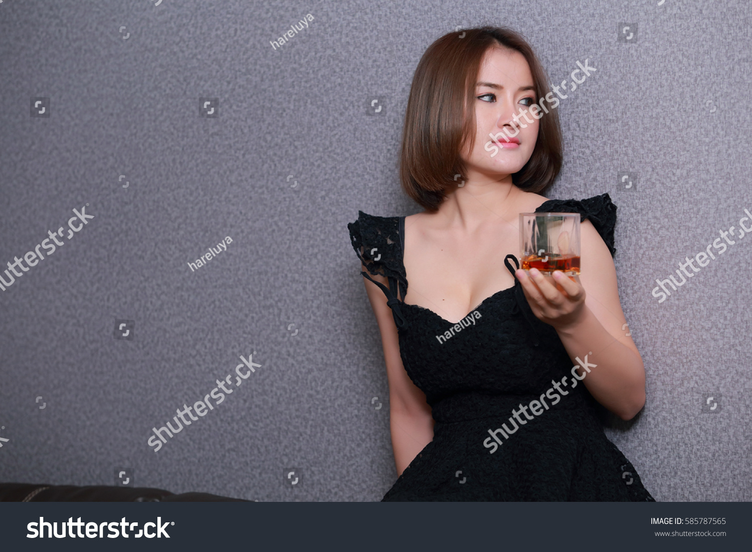 Asian woman with short hair, beautiful skin.Holding a glass of brandy only one.International Women's Day 2017. #585787565