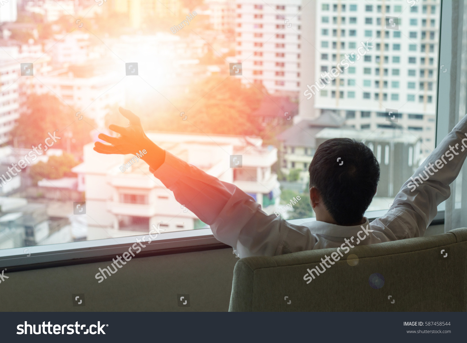 Easy relax business man lifestyle at home sitting on modern chair in living room looking out of window toward beautiful cityscape downtown urban landscape city life w/ sunlight effect: happy people #587458544