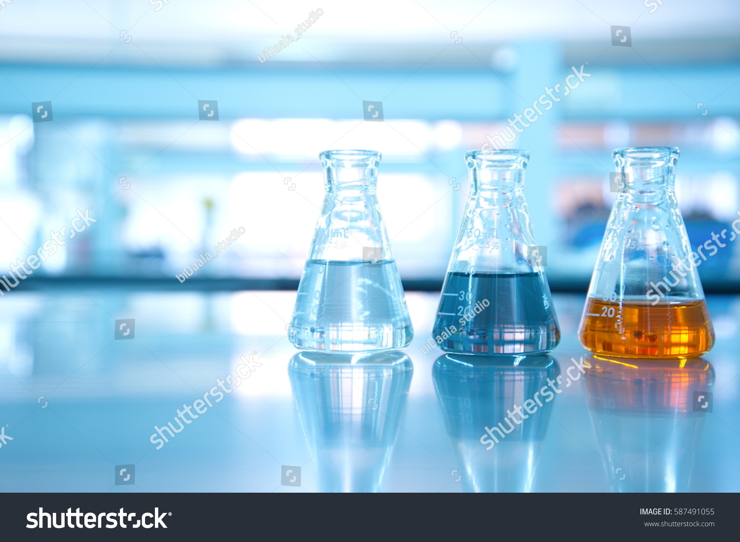 three flask of water black orange solution in science laboratory background #587491055