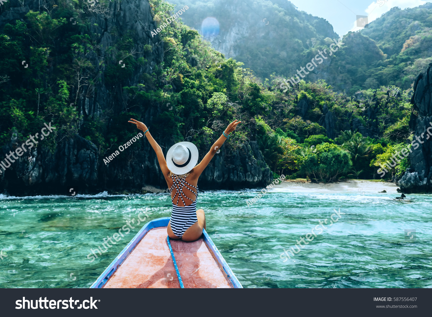 Back view of the young woman in hat relaxing on the boat and looking at the island. Travelling tour in Asia: El Nido, Palawan, Philippines. #587556407