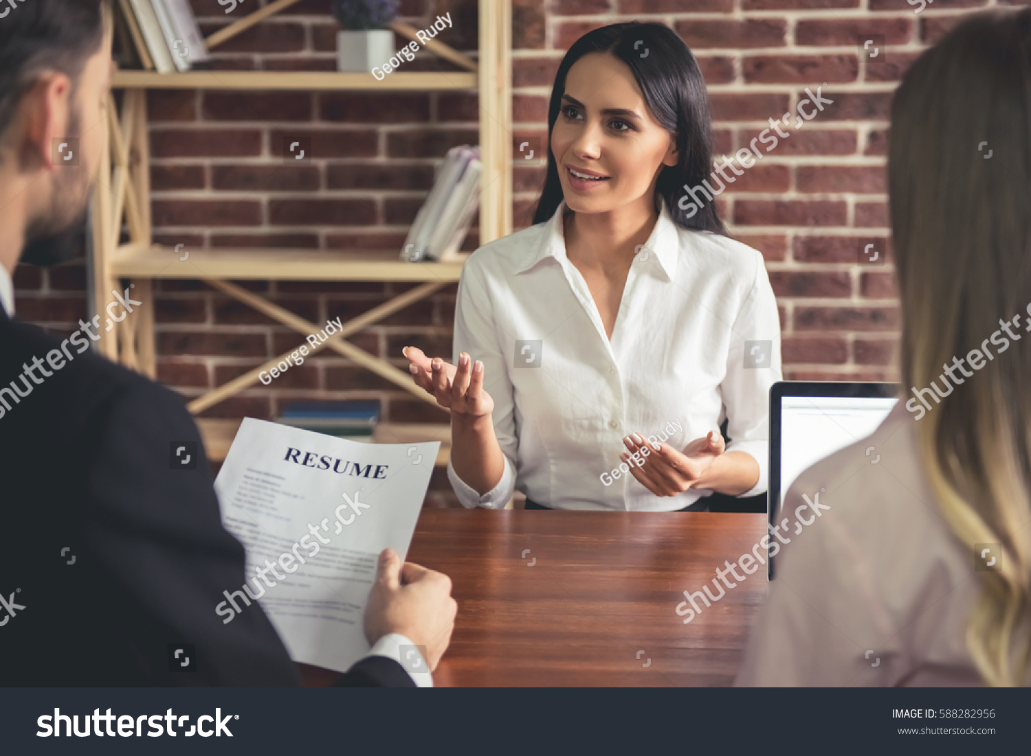 Beautiful female employee in suit is smiling during the job interview #588282956