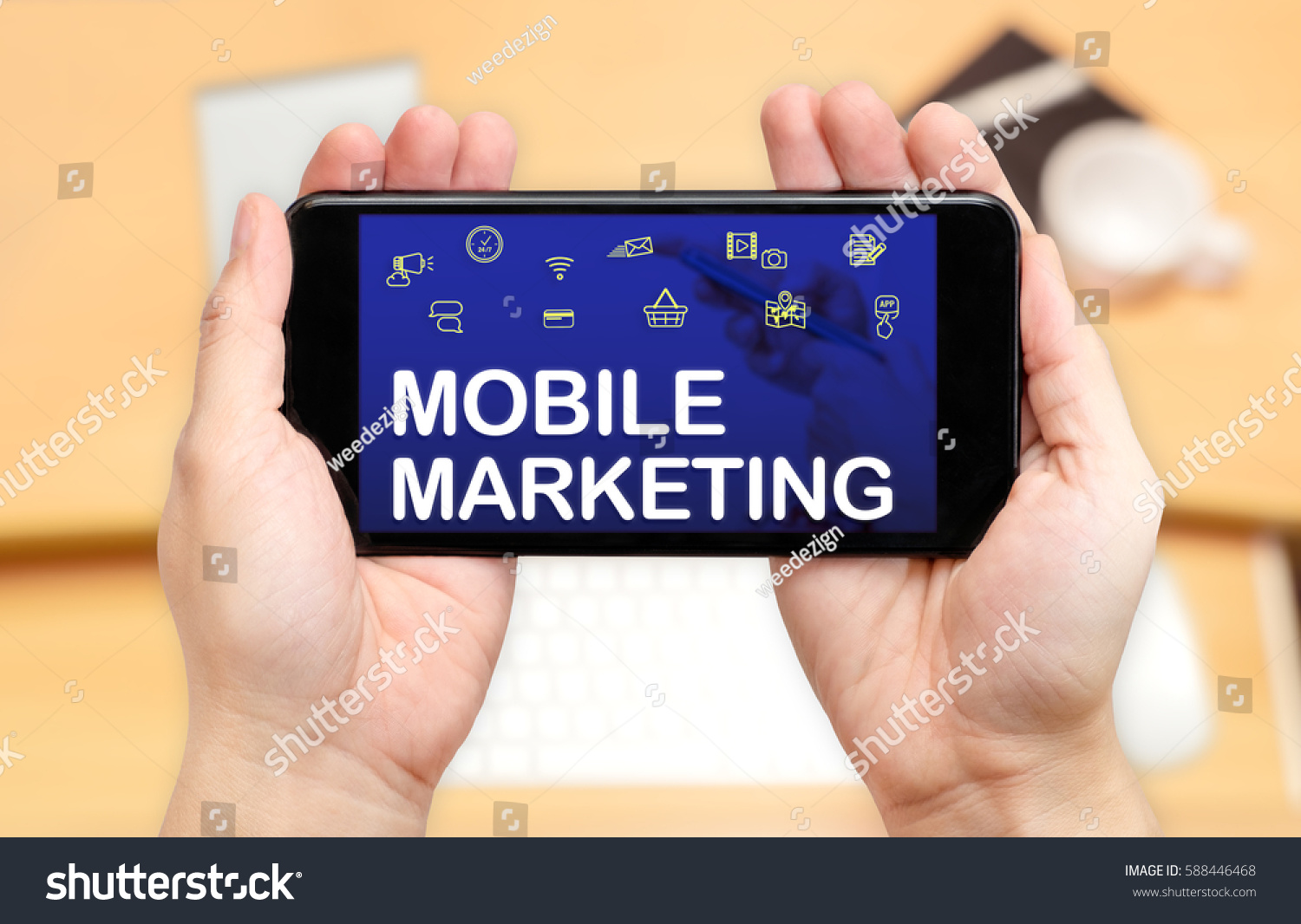 Watching two hand holding mobile phone with Mobile marketing word on screen and blur desk office background,Digital content concept #588446468