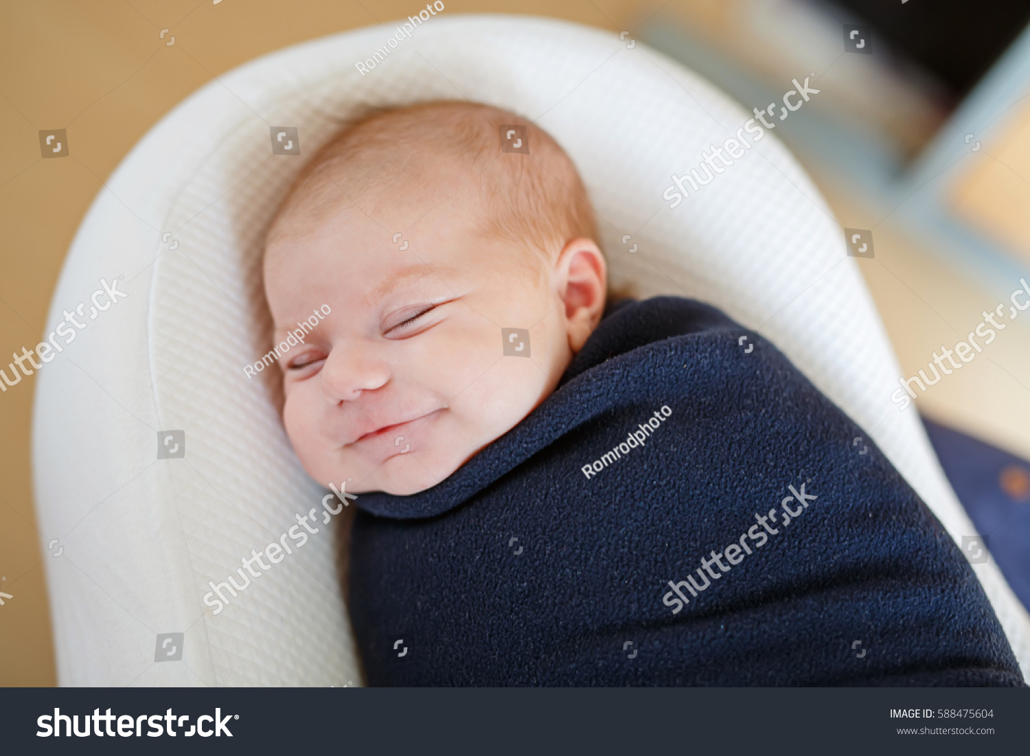 Cute adorable newborn baby wrapped in colorful blanket, sleeping and dreaming. Closeup of peaceful child, little baby girl . Family, Birth, new life. Swaddling as method for calm child #588475604
