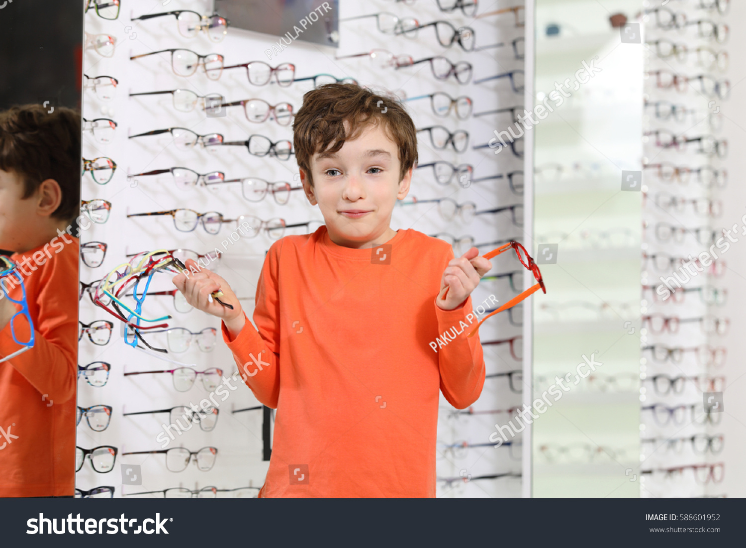 choosing glasses at optics store 
 #588601952