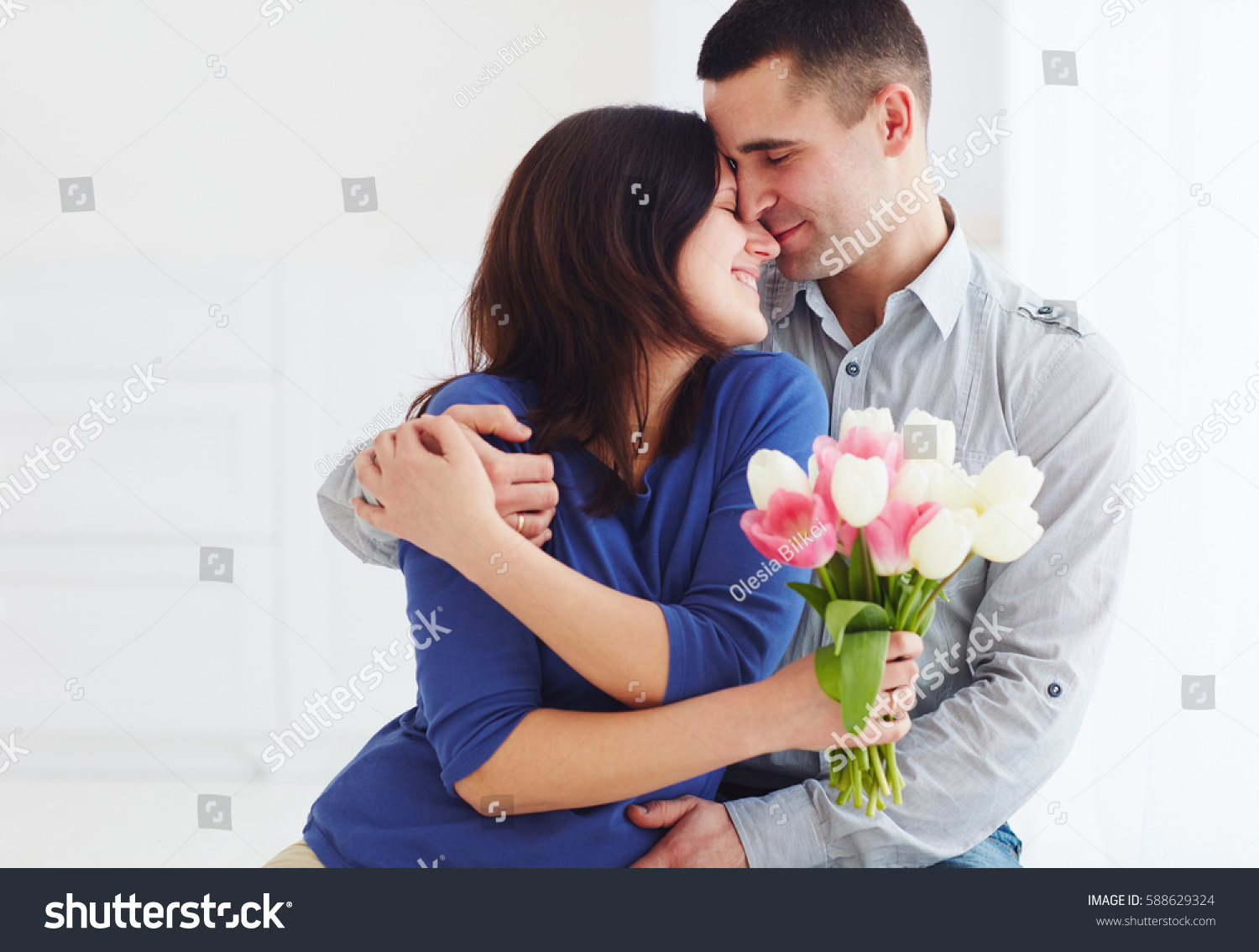 portrait of happy couple, husband and wife with spring flower bouquet #588629324