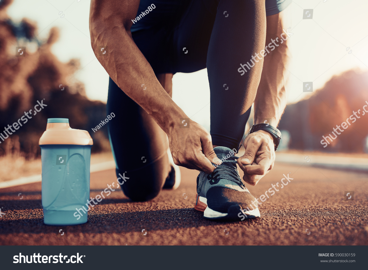 Young male jogger athlete training and doing workout outdoors in city. #590030159