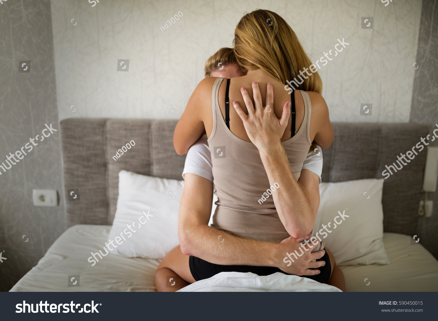 Romantic couple in bed being intimate #590450015