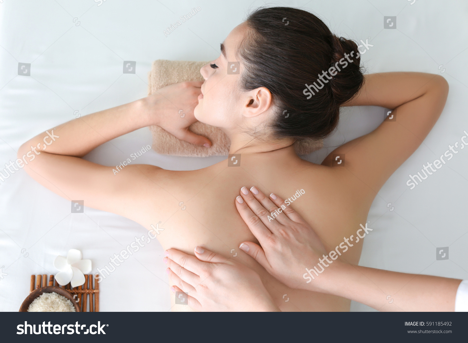 Beautiful young woman receiving massage in spa salon #591185492