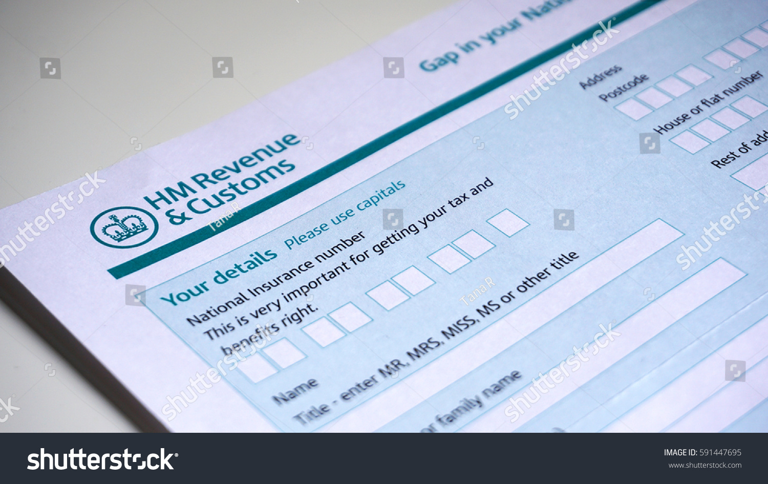 Photo of filling in a HM customs form a personal details for UK self assessment tax and benefits right. #591447695