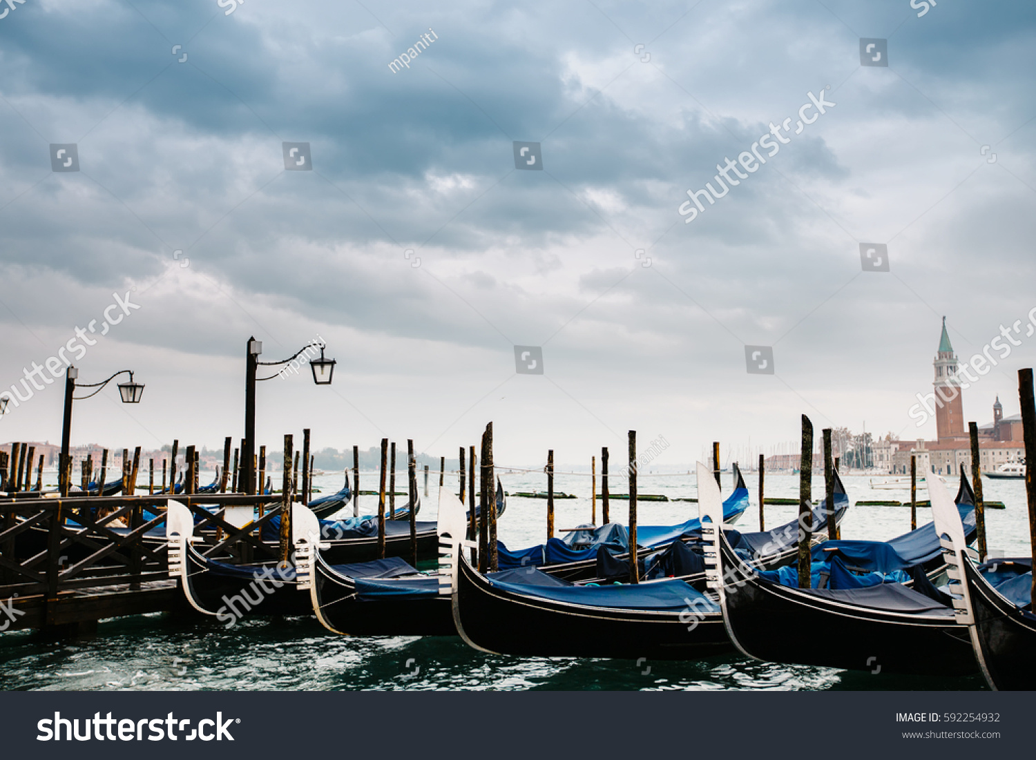 Grand canal in Venice, Piazza San Marco, in the background the island San Giorgio. Beautiful moody cityscape with gondolas. #592254932