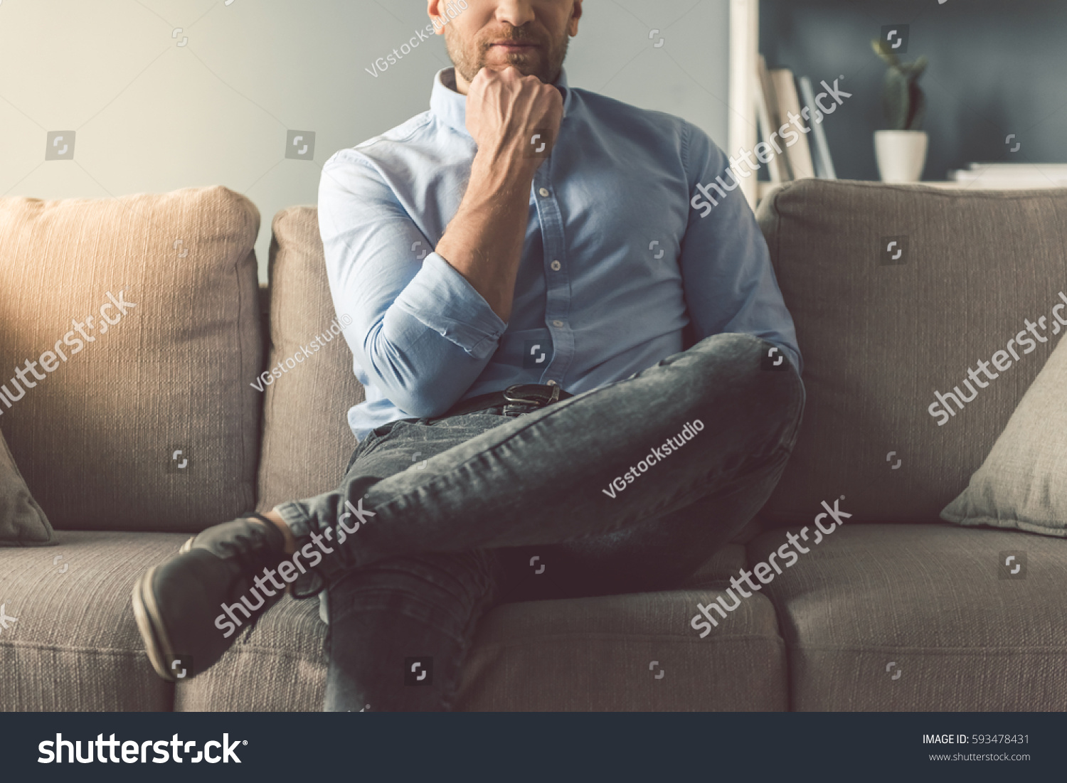 Cropped image of handsome man sitting on couch at home #593478431