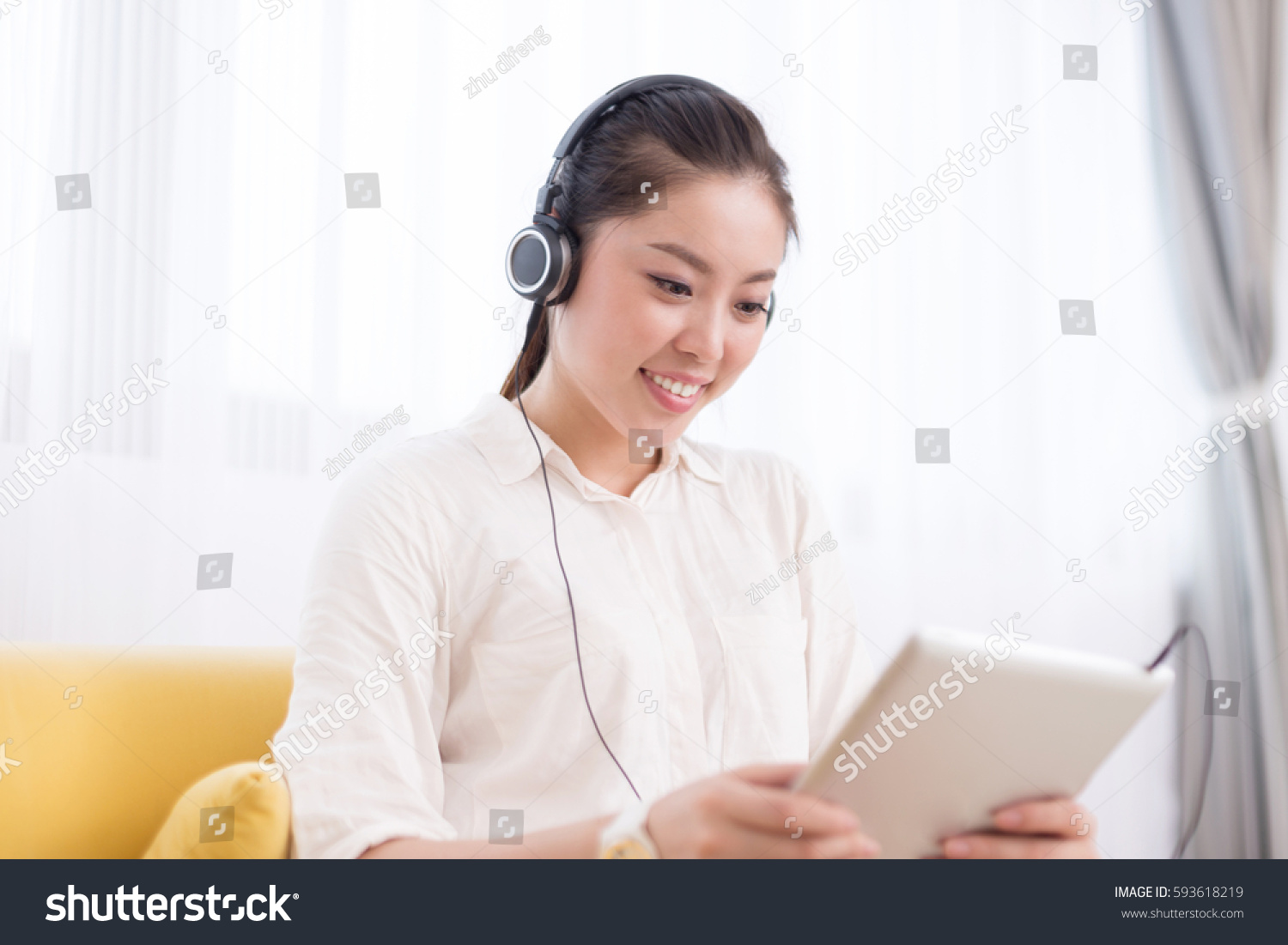 young pretty chinese woman listening music in room #593618219
