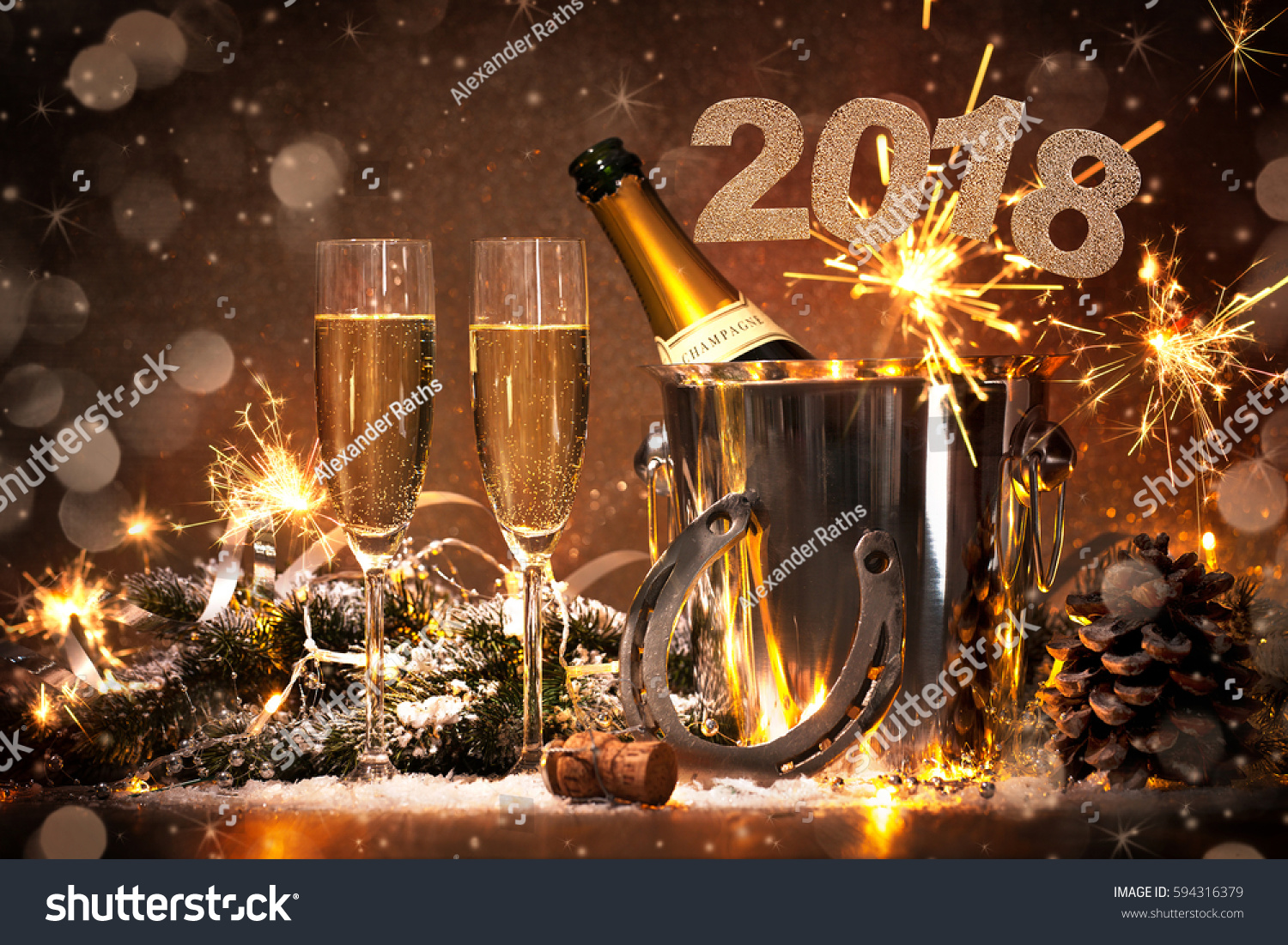 New Years Eve celebration background with pair of flutes and bottle of champagne in  bucket  and a horseshoe as lucky charm #594316379