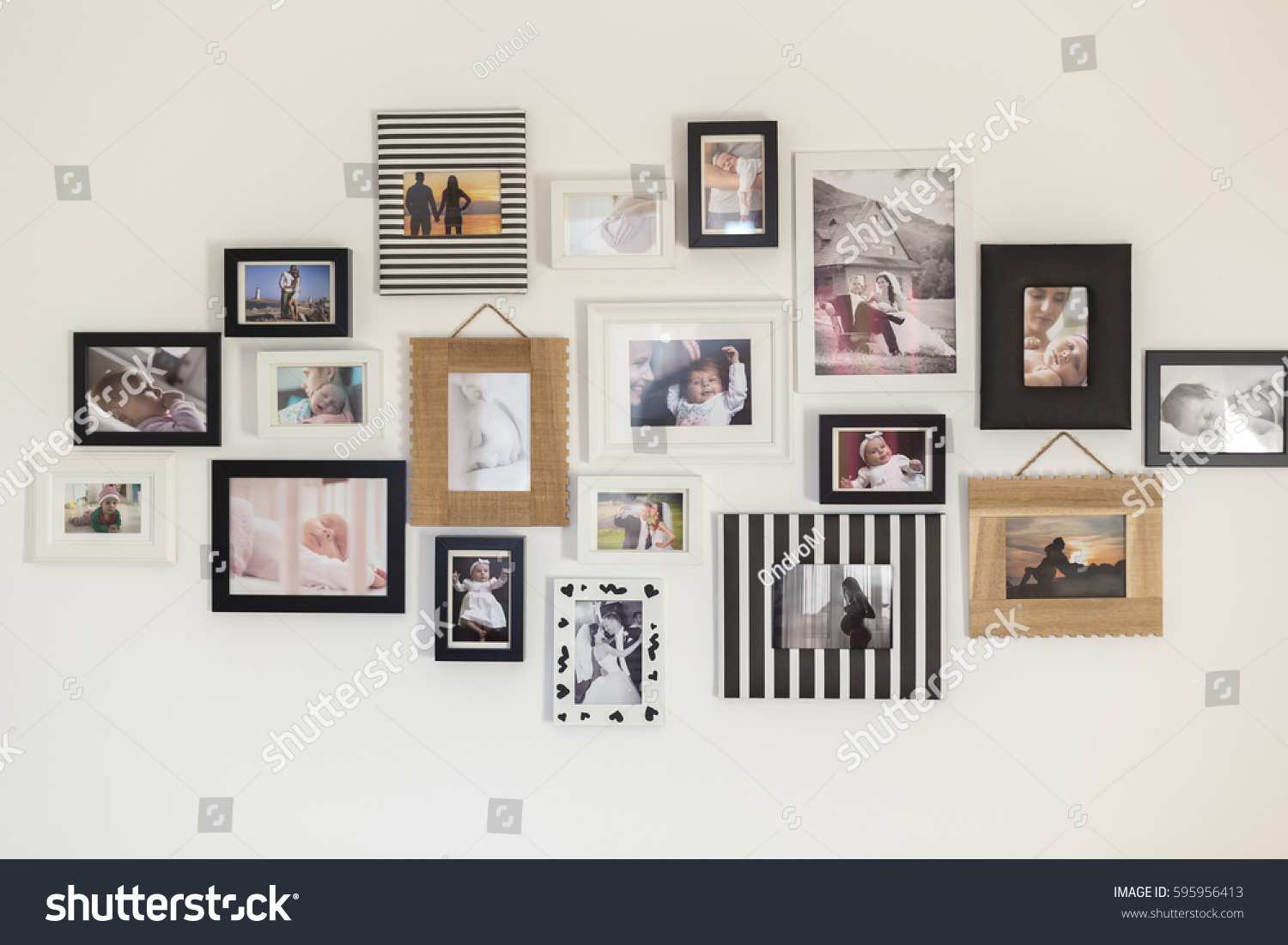 white wall with photos of the family in various photo frames #595956413