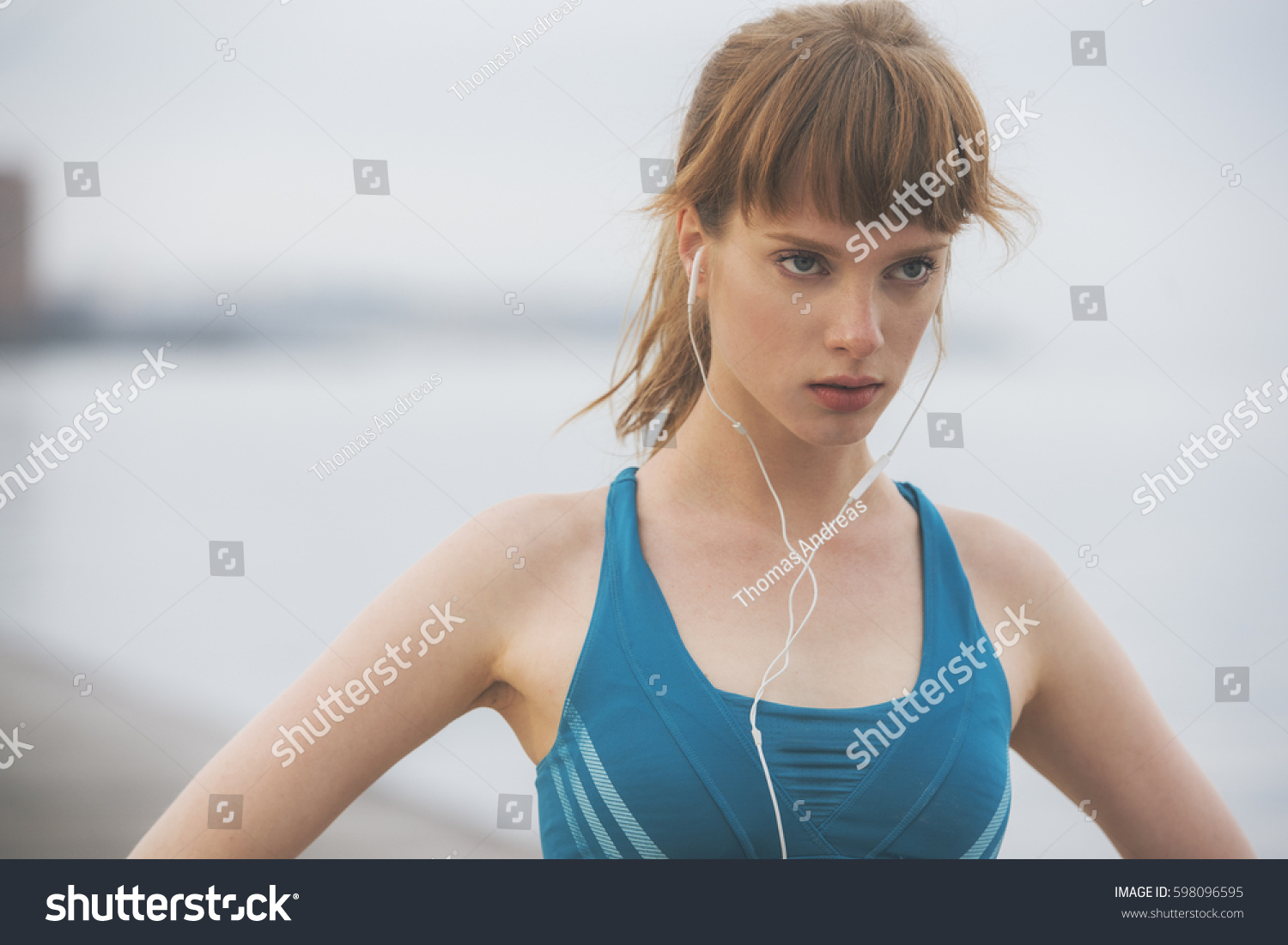 close up of a determined woman athlete running by the seaside in urban city environment #598096595