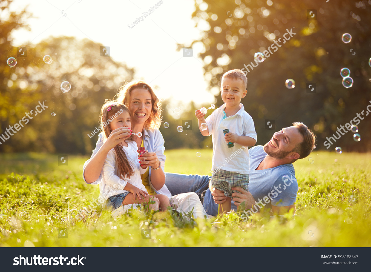 Family with children blow soap bubbles outdoor #598188347
