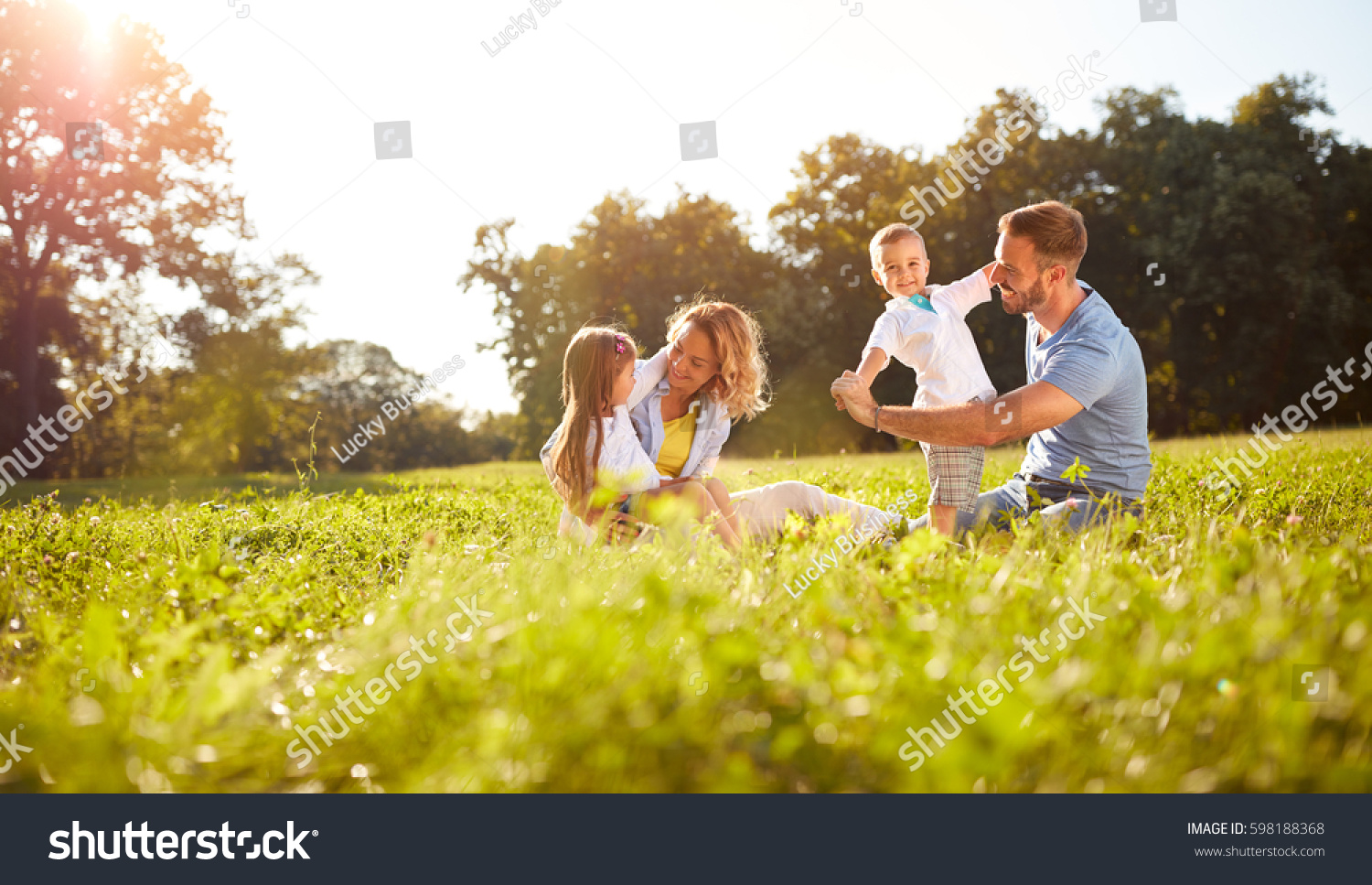 Happy male and female playing with children outside