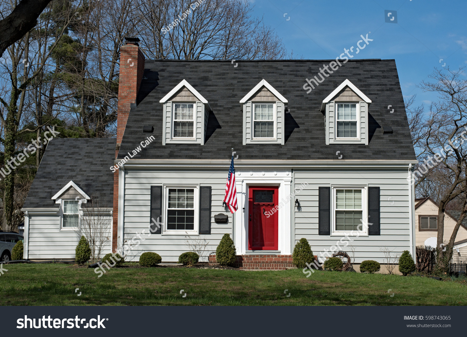 Cape Cod House with Three Dormers & Red Door #598743065