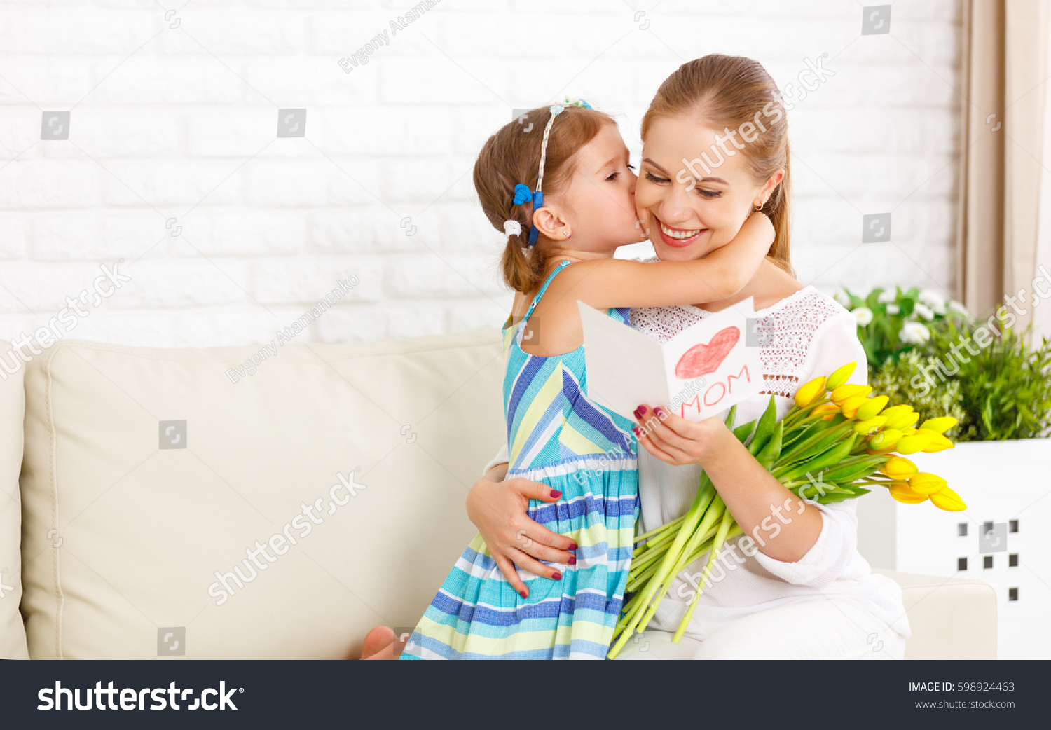 Happy mother's day! Child daughter congratulates moms and gives her a postcard and flowers tulips
 #598924463