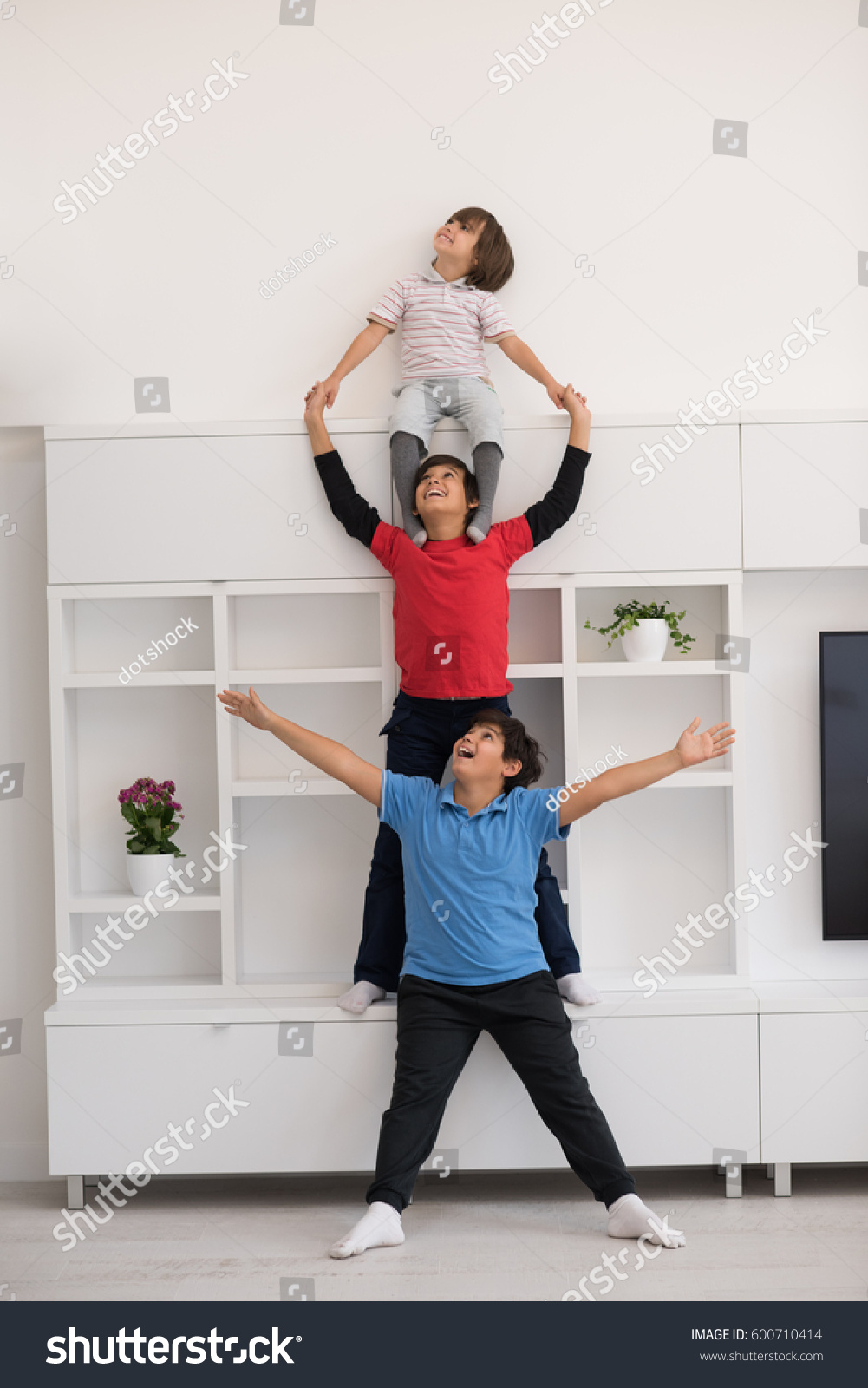 happy young boys having fun and posing line up piggyback in new modern home #600710414