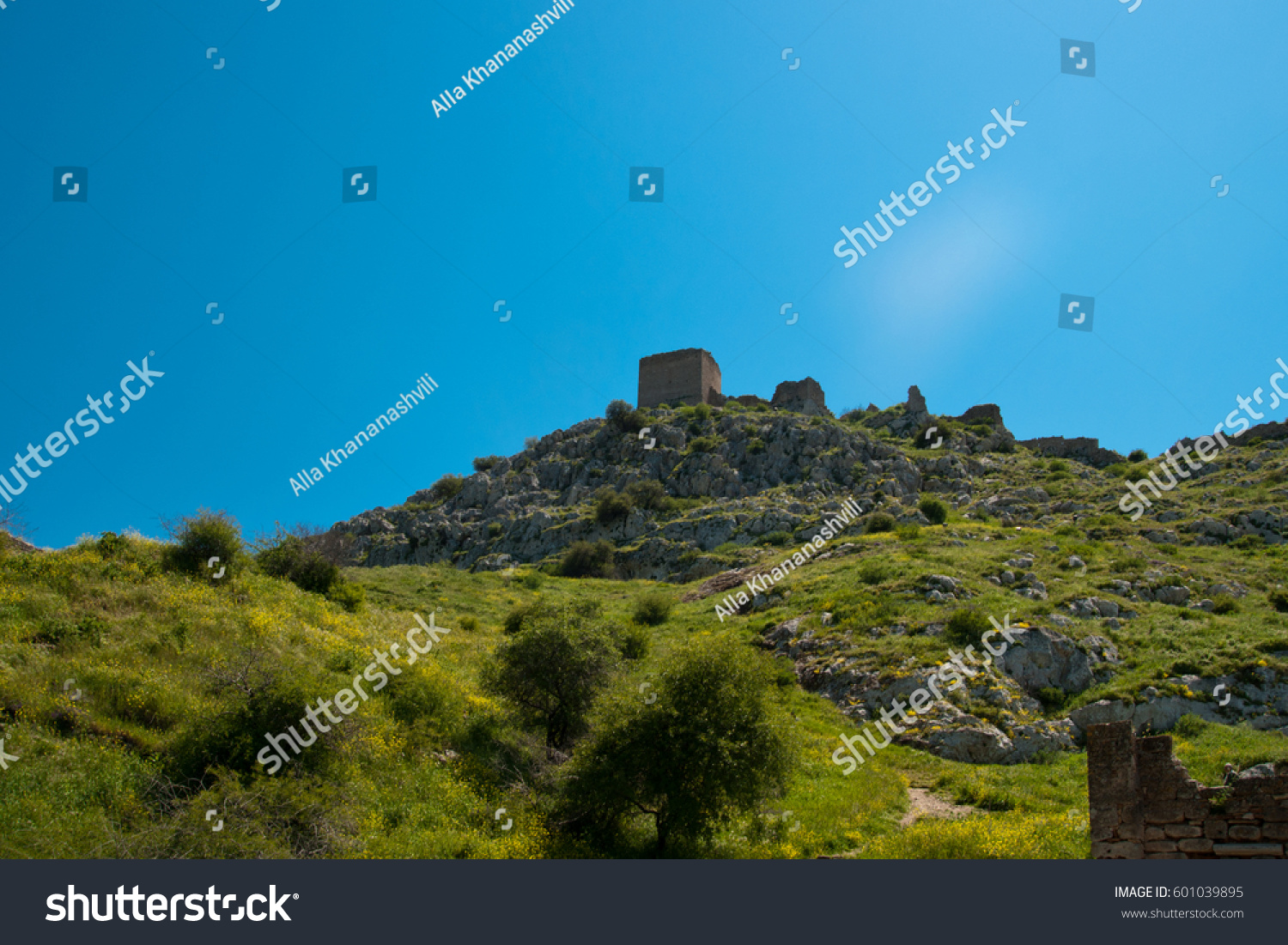 The ruins of medieval fortress of Acrocorinth up on the hill, the inner part is surrounded by old walls, on a bright sunny day, Peloponnese, Greece #601039895