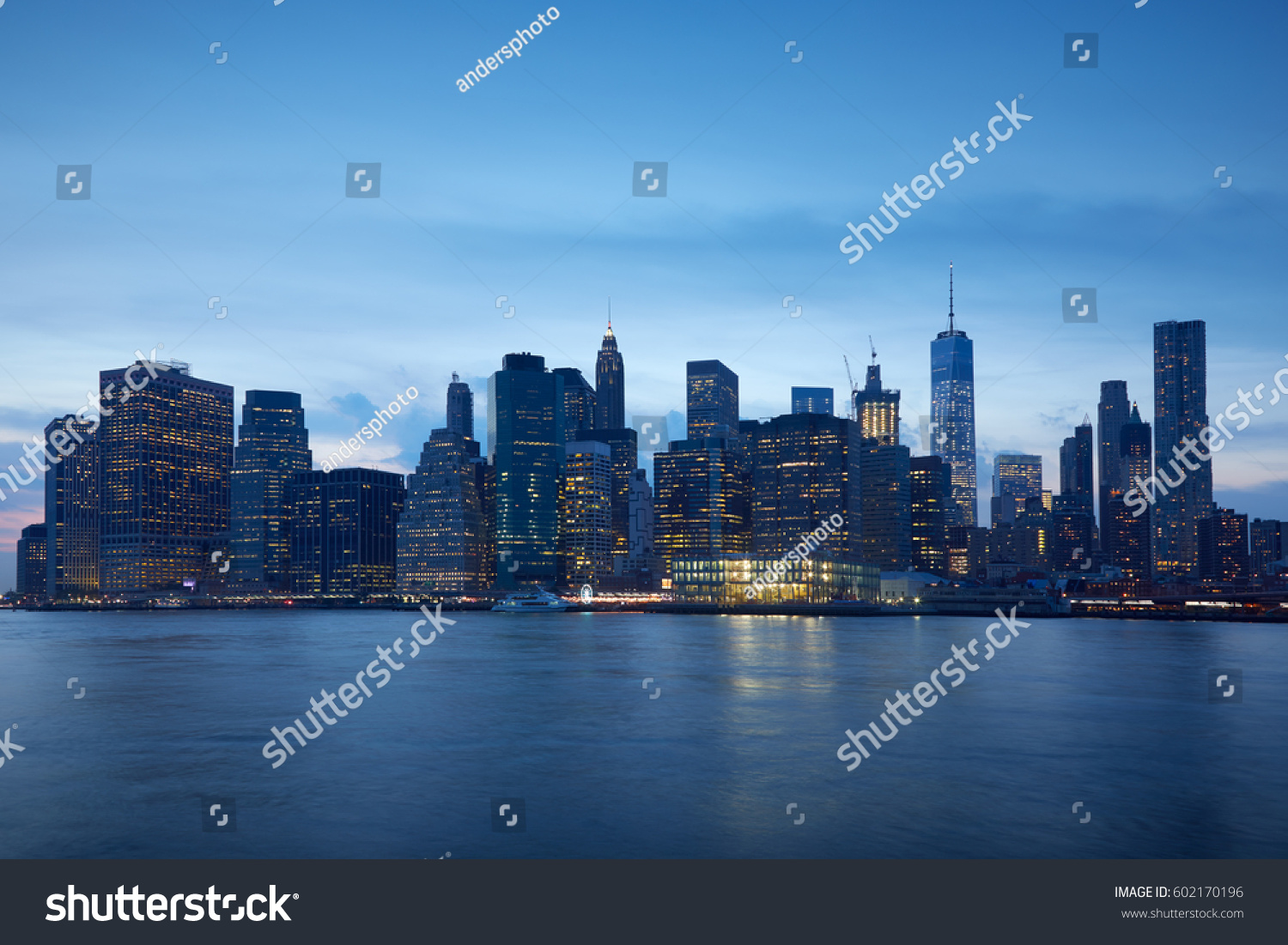 New York city skyline with illuminated buildings in the blue evening hour #602170196