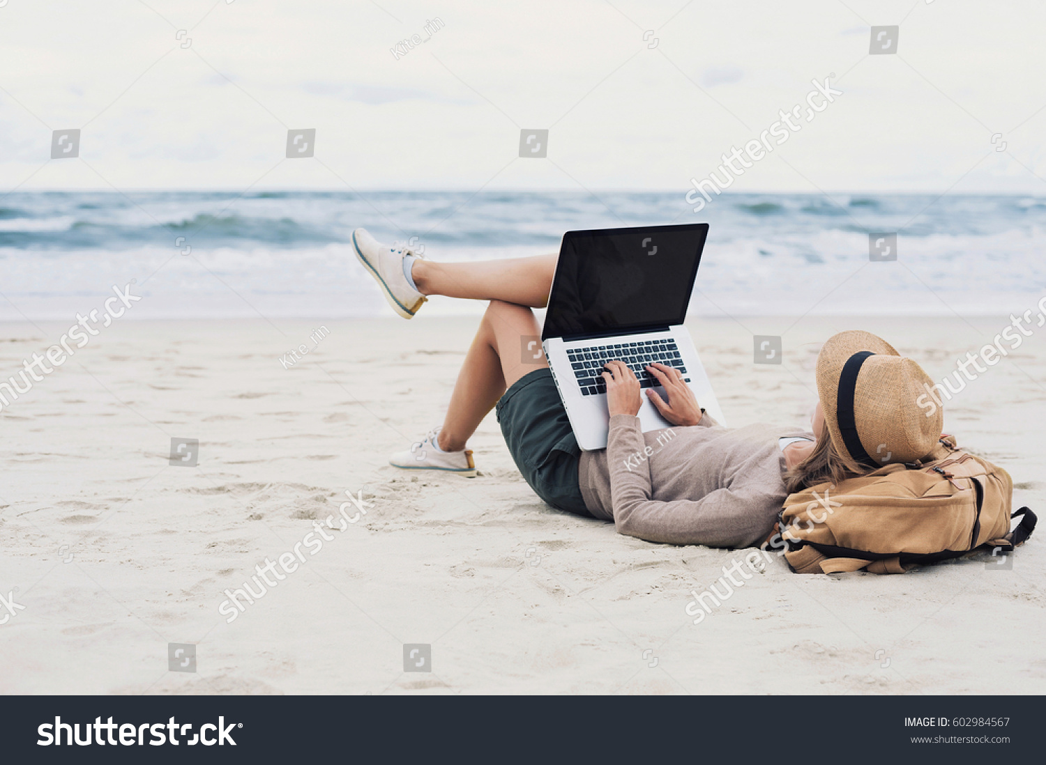 Young woman working, using laptop computer on a beach. Freelance work, vacations, distance work, social distancing, e-learning, connection, creative professional, new business, meeting online concept #602984567