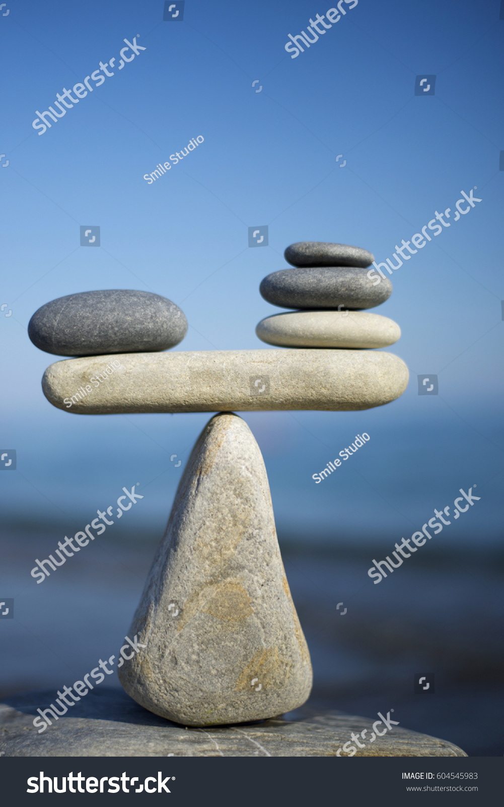  Balance of stones on a blue sky background with a copy space. To weight pros and cons. #604545983