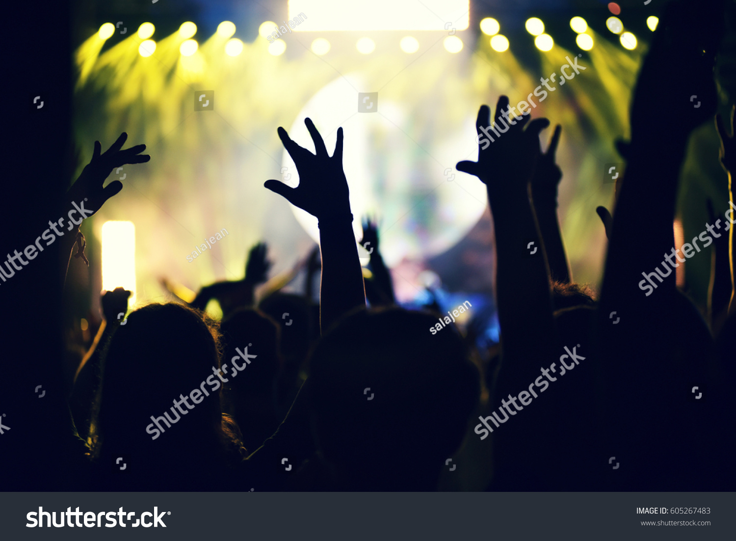 Crowd rocking during a concert with raised arms. Toned image #605267483