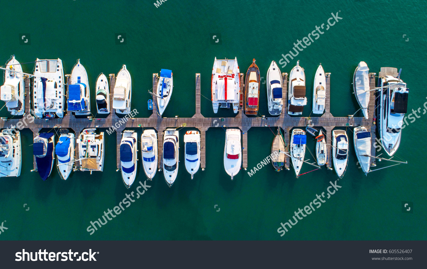 Pier speedboat. A marina lot. This is usually the most popular tourist attractions on the beach.Yacht and sailboat is moored at the quay.Aerial view by drone.Top view. #605526407