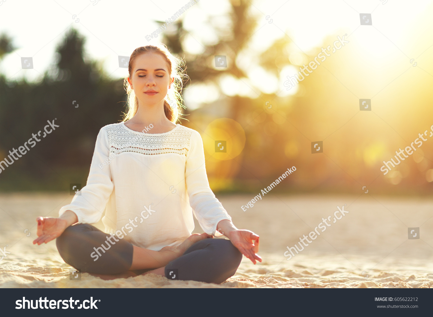 woman practices yoga and meditates in the lotus position on the beach
 #605622212