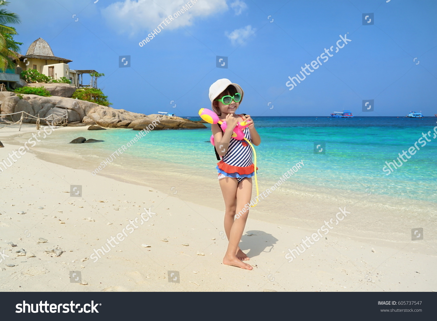 Children play in the sand at the beach.Kids playing water gun.Summer sea travel.Summer beach travel.  #605737547