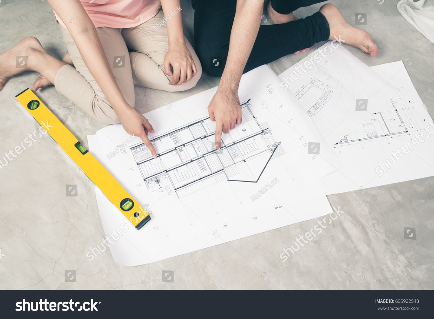 Attractive young asian adult couple looking at house plans. #605922548