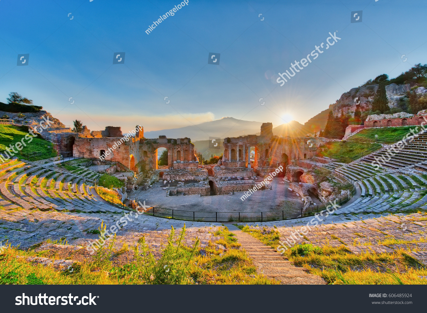 Ancient theatre of Taormina Siciliy Italy  with Etna erupting volcano at sunset #606485924